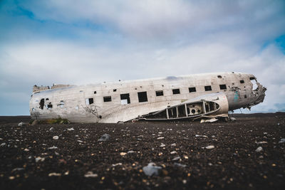 Abandoned airplane on field against sky