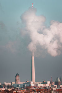 Fernsehturm covered with smoke against sky