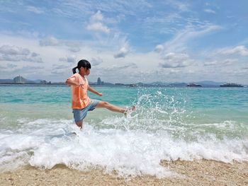 Full length of man enjoying at beach against sky