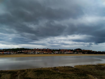 Bridge over river amidst buildings against sky