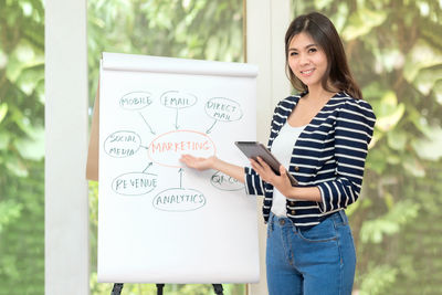 Portrait of smiling woman standing by text
