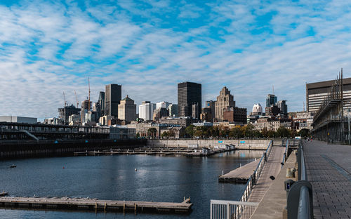 River by buildings in city against sky