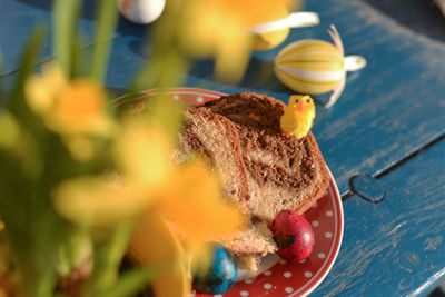 High angle view of easter eggs and cakes in plate on table