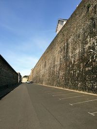 Empty road amidst buildings against sky