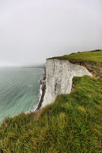 Scenic view of white cliffs of dover and sea against clear sky