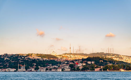 City by sea against sky during sunset