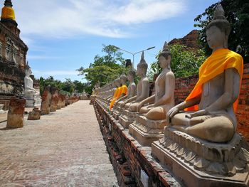 Statue of temple against building and sky