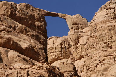 Low angle view of natural arch in desert against sky