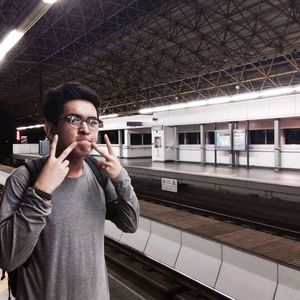 Portrait of man gesturing at subway station