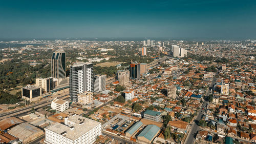 High angle view of buildings in city against clear blue sky