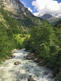 Scenic view of river amidst mountains against sky