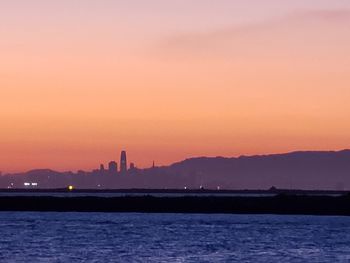 Scenic view of sea against orange sky