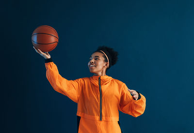 Young man playing basketball at night