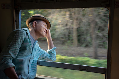 Thoughtful mature man looking through train window