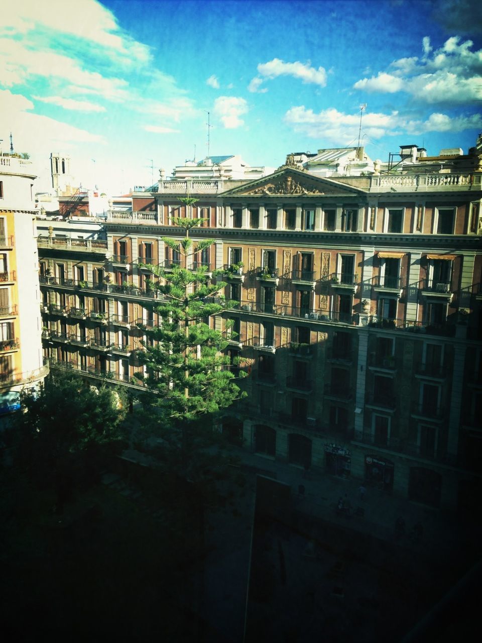 architecture, building exterior, built structure, sky, city, building, residential building, low angle view, residential structure, sunlight, tree, cloud - sky, railing, cloud, day, window, outdoors, no people, balcony, growth