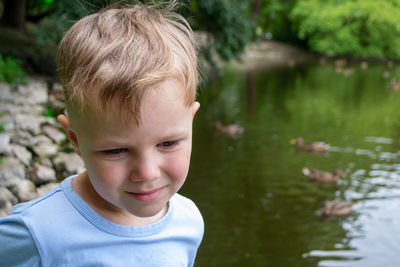 Small boy playing on a pond