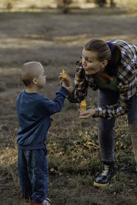 A boy, person with down syndrome walks in the park with his mother, soap bubbles