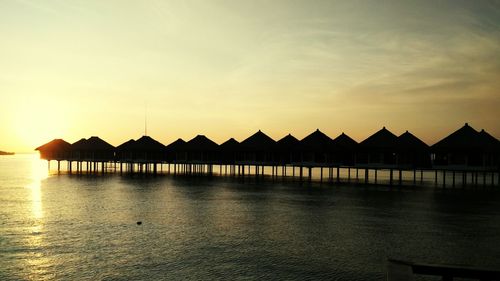 Silhouette pier on sea against sky during sunset