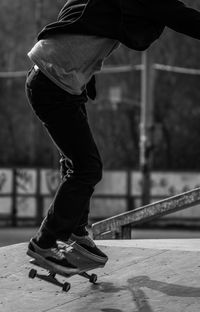 Low section of man skateboarding at park