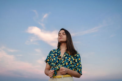 Low angle view of woman standing against sky