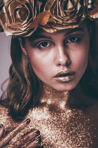 Close-up portrait of young woman with shiny glitters