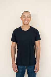 Portrait of young man standing against white background