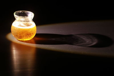 Close-up of wineglass on table against black background