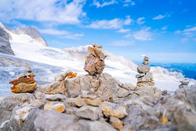 Stack of stones on rocks at mountain against sky