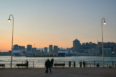 City skyline from the harbor of genoa at sunset, liguria, italy