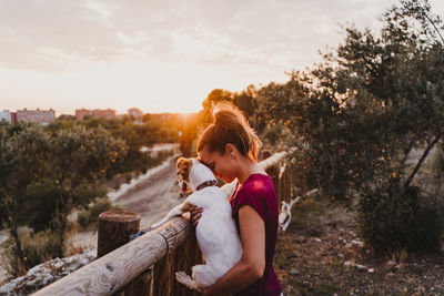 Full length side view of woman walking on street during sunset