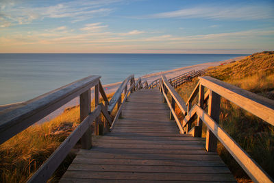 Pier over sea against sky during sunset