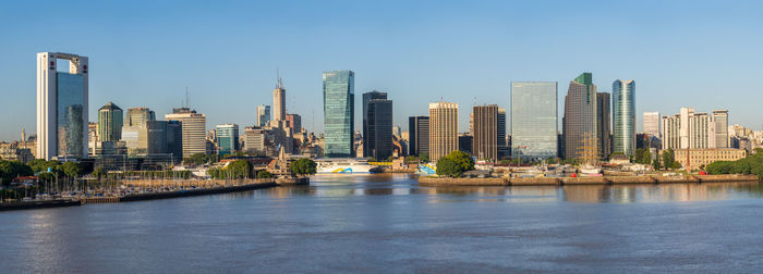 Modern buildings in city against clear blue sky