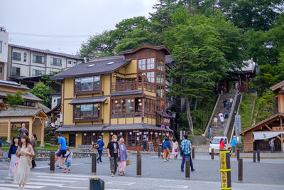 People on street amidst buildings in city