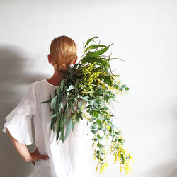 Woman standing by white flowering plant