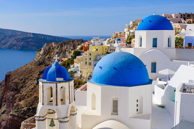 Panoramic view of sea and buildings against blue sky