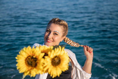 Portrait of smiling woman by sea