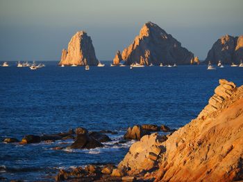 Rock formations by sea against sky