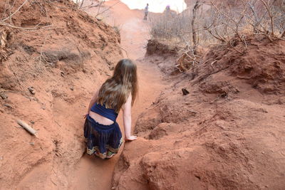 Rear view of girl standing on rock formation