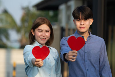 Portrait of happy couple holding heart