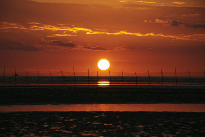 Scenic view of sea against orange sky