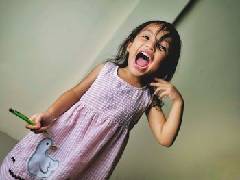 Portrait of a happy girl against wall