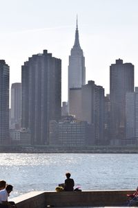 Manhattan by east river against sky seen from gantry plaza state park