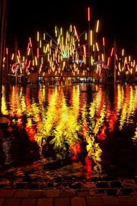 Illuminated harbor against sky at night