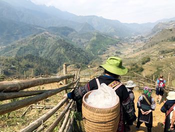 Rear view of people on landscape against mountains