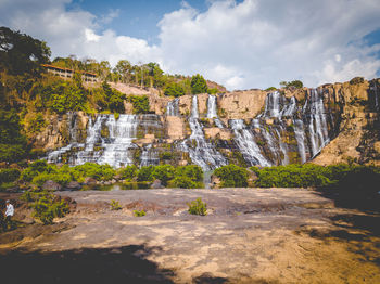 Scenic view of waterfall against sky