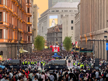 A vibrant crowd gathers at a lively event with police presence for safety and security
