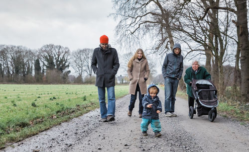 Family walking by field on road