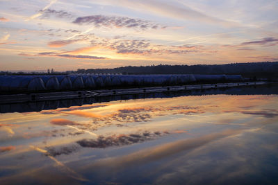 Scenic view of frozen landscape against sky during sunset