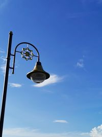 Low angle view of street light against blue sky