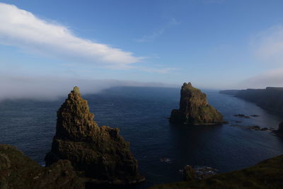 Scenic view of rock formation in sea against sky